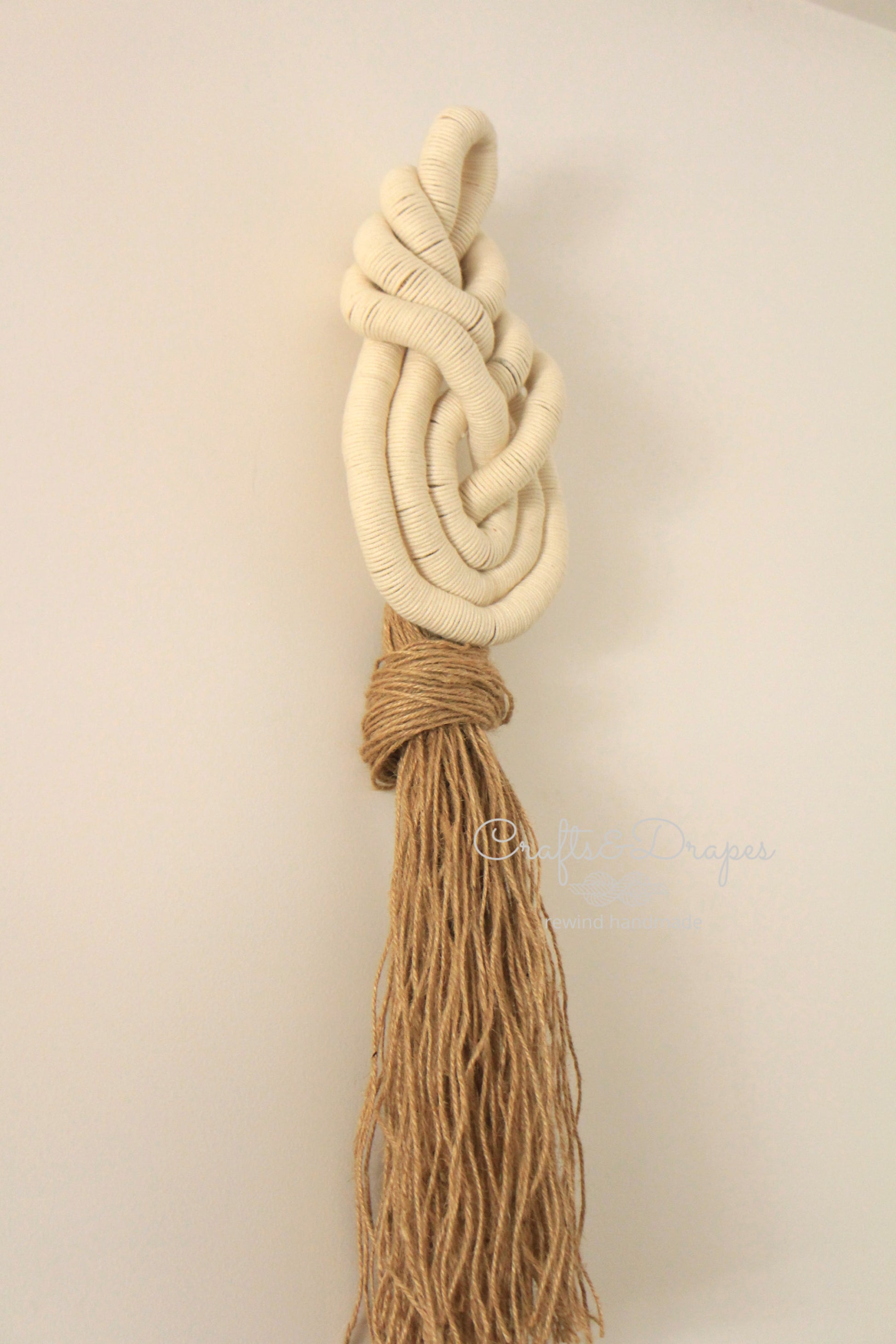 Organic and textural handwrapped jute wall art, showcasing intricate patterns and natural hues, adding a rustic and contemporary feel to the room